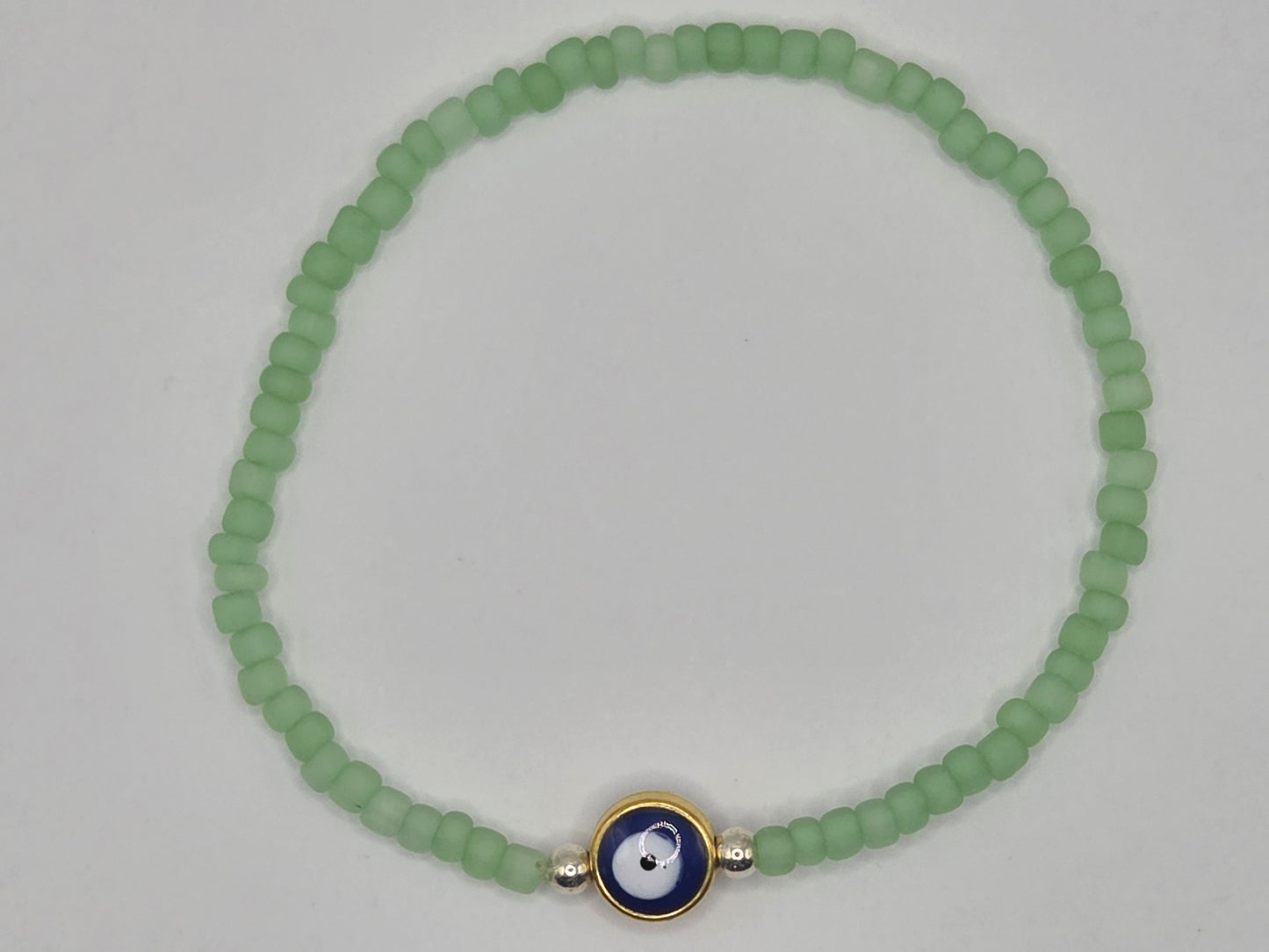 Handmade bracelet in mint green with Evil Eye – delicate protective jewelry